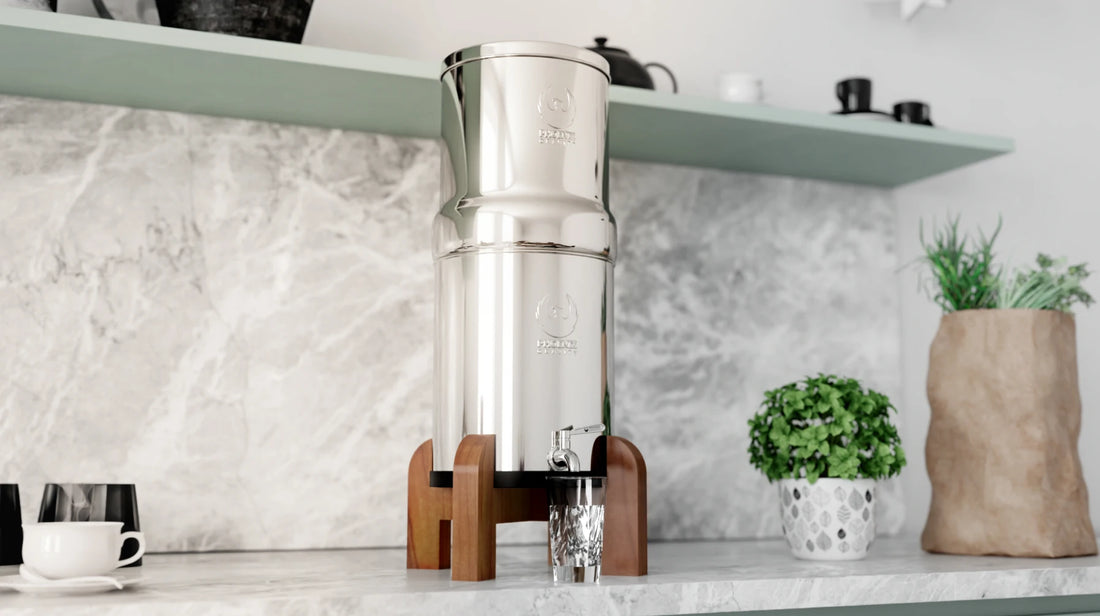 Stainless steel coffee maker on a kitchen counter with a marble backsplash.